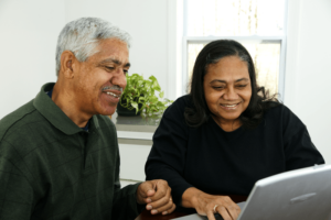 Happy older couple looking at laptop